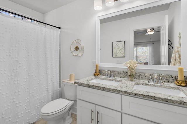 full bath with a sink, a ceiling fan, toilet, and double vanity