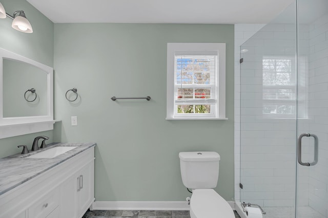 full bath with toilet, a shower stall, baseboards, and vanity