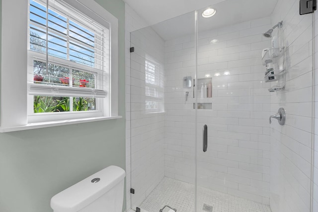 bathroom featuring a stall shower and toilet