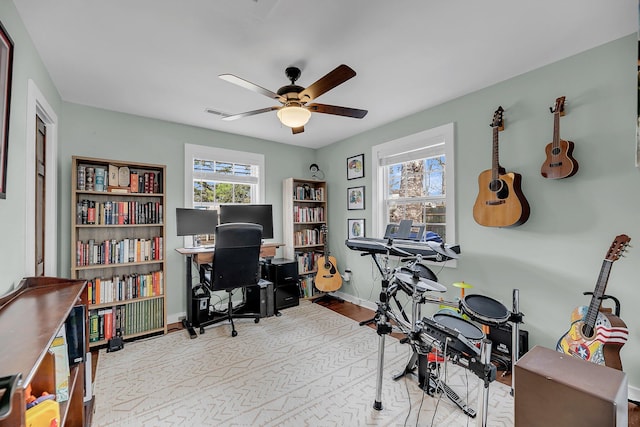 office space with ceiling fan and baseboards