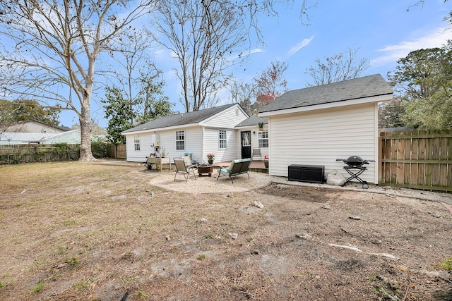 rear view of property with a yard, a patio area, and a fenced backyard