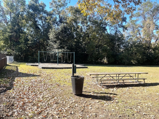 view of yard featuring playground community and fence