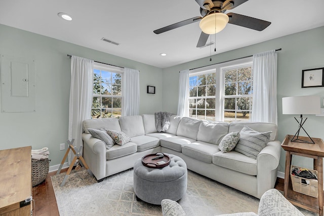 living room with recessed lighting, wood finished floors, visible vents, baseboards, and electric panel