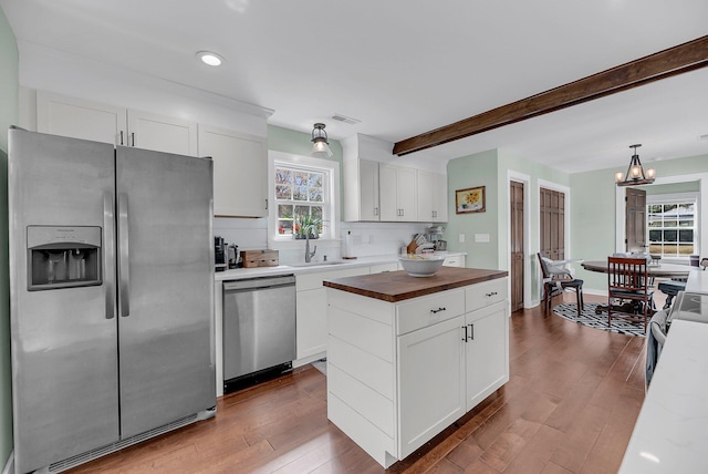 kitchen featuring stainless steel appliances, a wealth of natural light, visible vents, wooden counters, and white cabinets