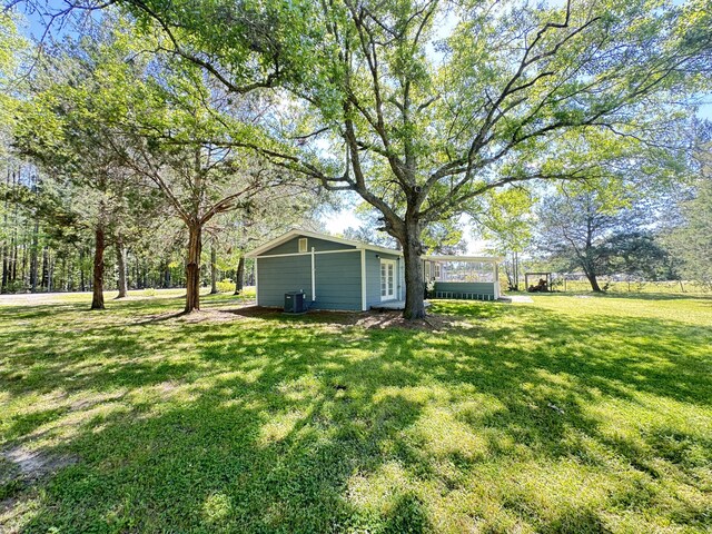 view of green lawn featuring central AC