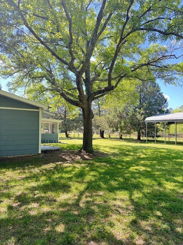 view of grassy yard with a carport