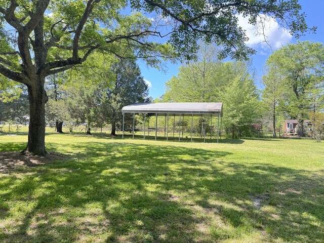 view of property's community featuring a detached carport and a lawn