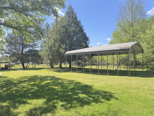 view of green lawn with a carport