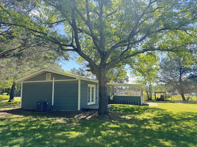 view of property exterior with french doors, a lawn, and central air condition unit