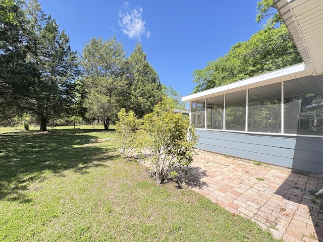view of green lawn featuring a sunroom
