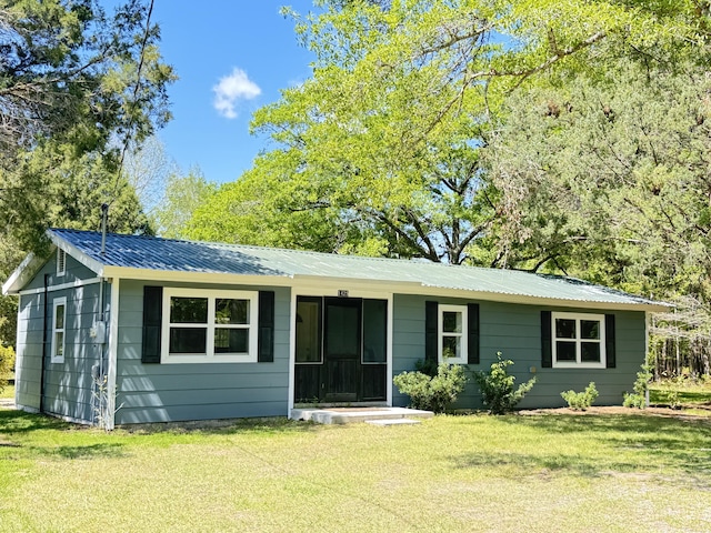 single story home with a front lawn and metal roof