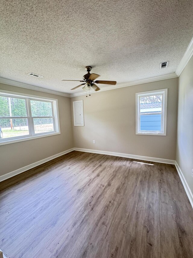 unfurnished room with crown molding, dark wood-style flooring, a textured ceiling, a ceiling fan, and baseboards