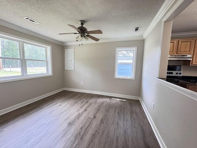 empty room with a ceiling fan, dark wood-style floors, ornamental molding, a textured ceiling, and baseboards