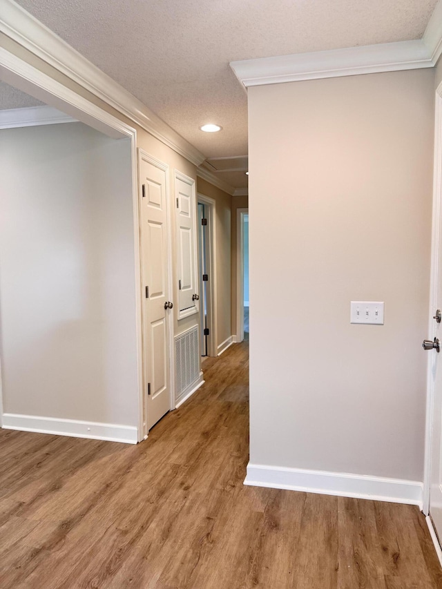 hallway with crown molding, baseboards, wood finished floors, and recessed lighting