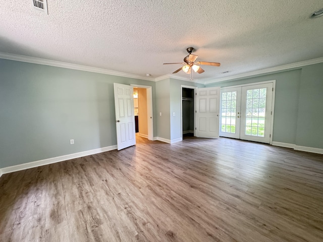 unfurnished bedroom with wood finished floors, crown molding, a textured ceiling, baseboards, and access to exterior