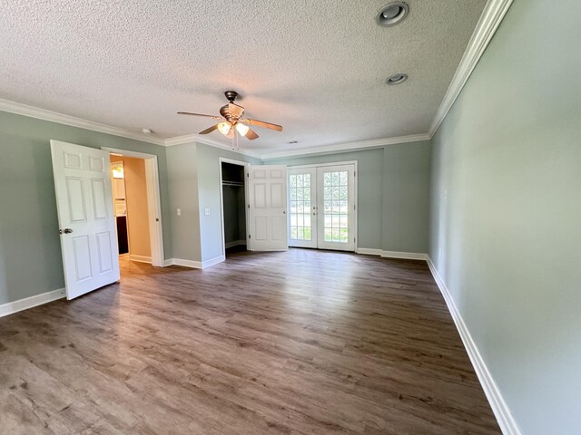 unfurnished bedroom featuring a textured ceiling, wood finished floors, ornamental molding, baseboards, and french doors