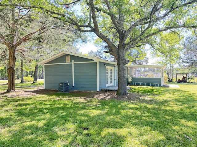 view of property exterior featuring french doors, cooling unit, and a yard