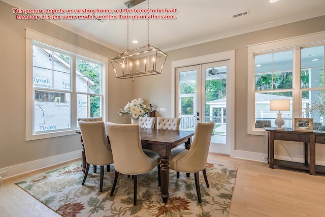 dining room with crown molding and light hardwood / wood-style flooring