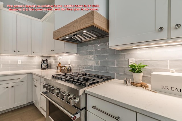 kitchen featuring high end range, backsplash, custom exhaust hood, and white cabinets