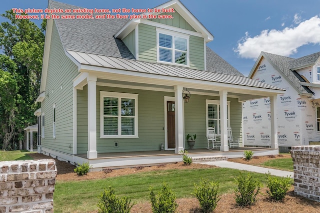 view of front of house with covered porch and a front lawn