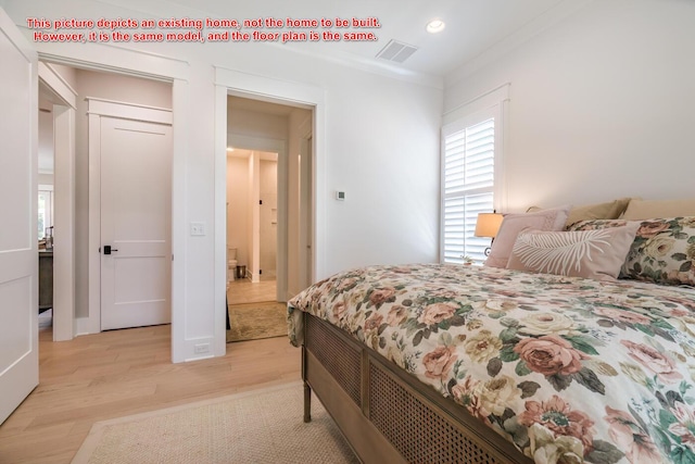 bedroom featuring crown molding and light hardwood / wood-style flooring