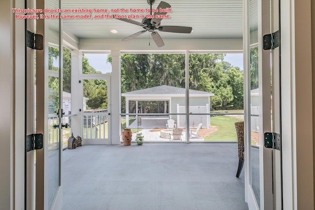 unfurnished sunroom featuring ceiling fan