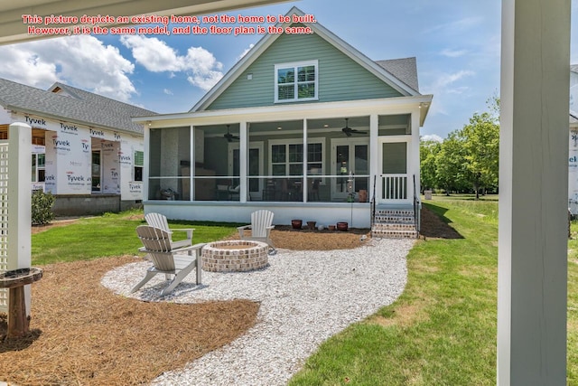 back of house featuring a yard, a fire pit, a sunroom, and ceiling fan