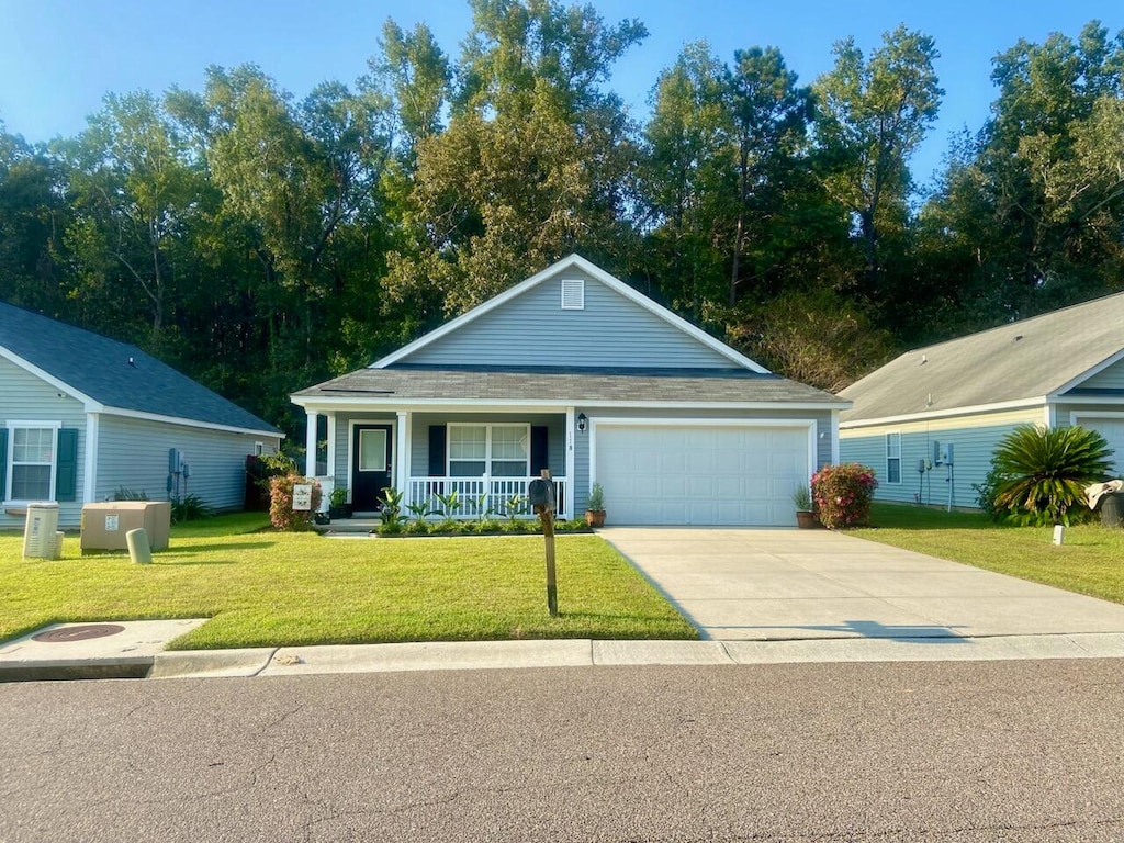 view of front of home featuring a front lawn, covered porch, and a garage