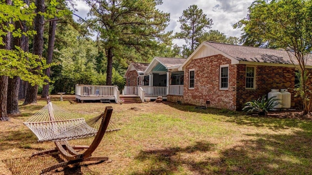 back of house with a deck and a yard