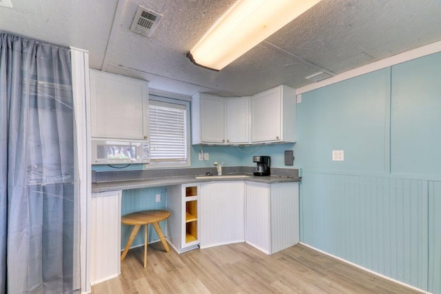 325 N 58th Ave, North Myrtle Beach, SC 29582 - kitchen featuring light wood-style floors, white cabinets, wainscoting, and open shelves