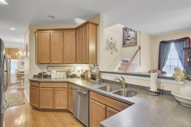 kitchen featuring sink, stainless steel appliances, light hardwood / wood-style flooring, and an inviting chandelier