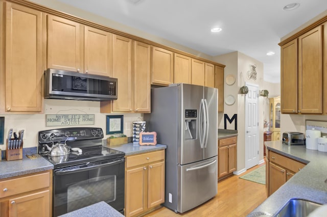 kitchen with light hardwood / wood-style floors, stainless steel fridge, and black electric range oven