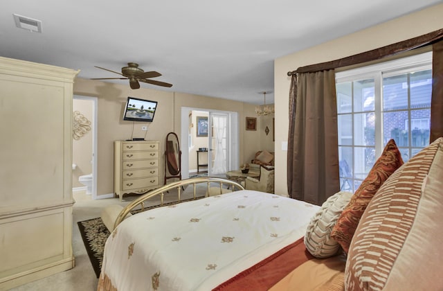 bedroom with ceiling fan, light carpet, and ensuite bath