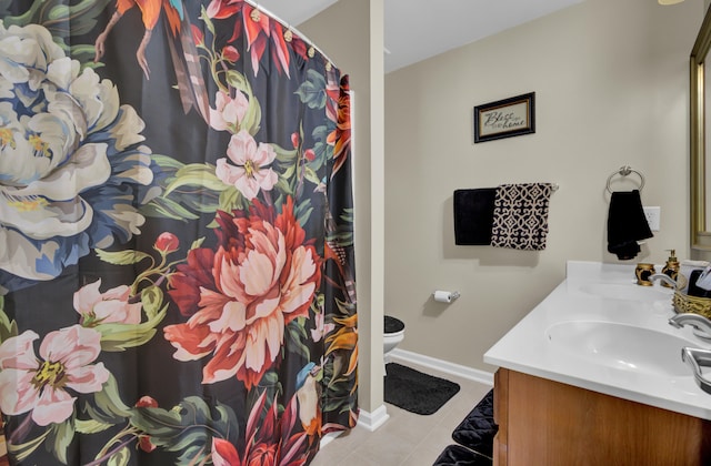 bathroom with toilet, vanity, and tile patterned floors