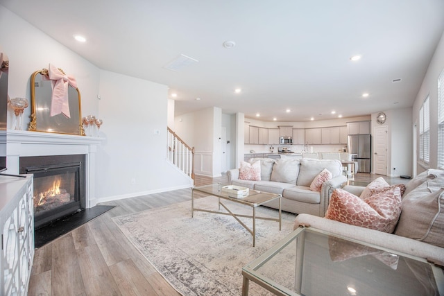 533 Richfield Way, Summerville, SC 29486 - living room featuring recessed lighting, light wood-style flooring, a glass covered fireplace, and stairway