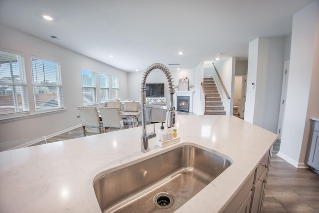 533 Richfield Way, Summerville, SC 29486 - kitchen with a lit fireplace, visible vents, a sink, light stone counters, and open floor plan