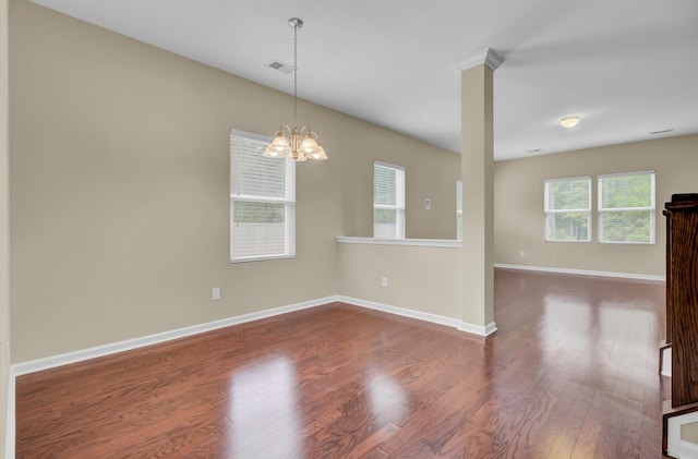 unfurnished room featuring a chandelier and dark hardwood / wood-style flooring