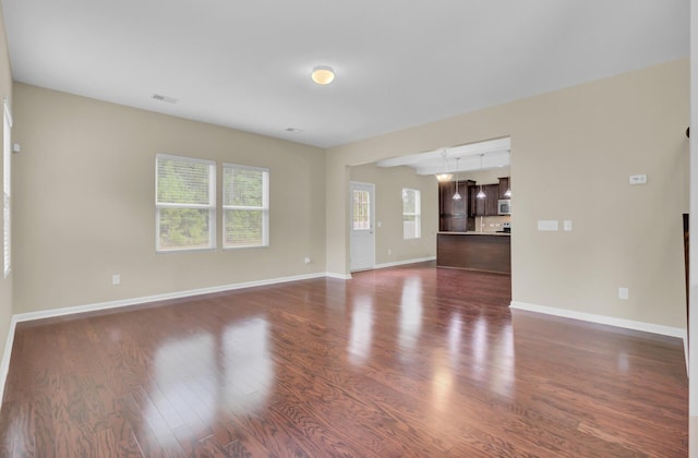 unfurnished living room with dark wood-type flooring