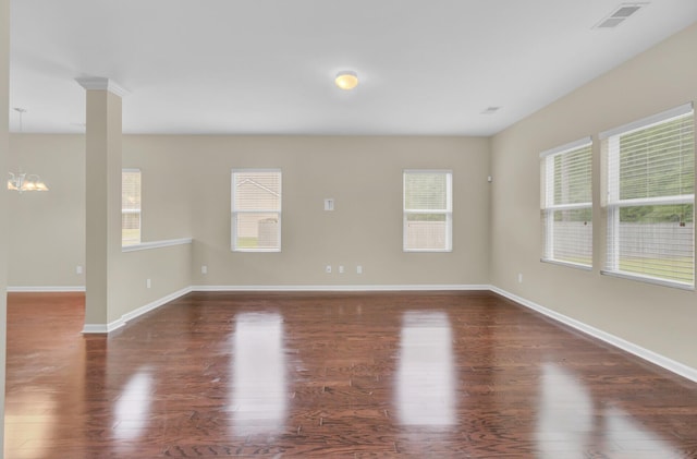 unfurnished room featuring a chandelier and dark hardwood / wood-style floors