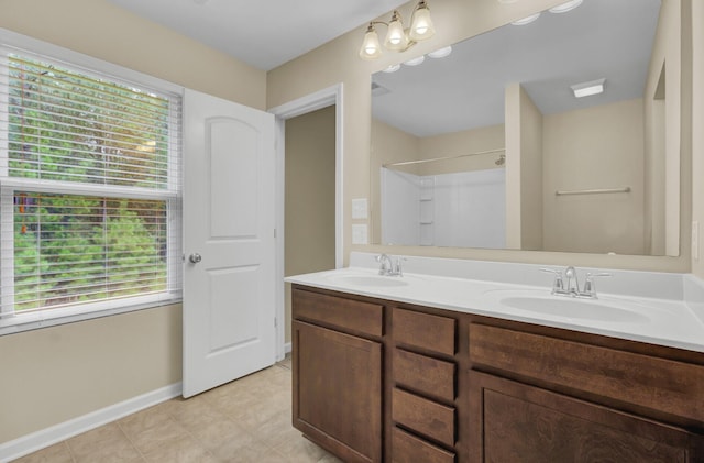 bathroom featuring vanity, a healthy amount of sunlight, and walk in shower