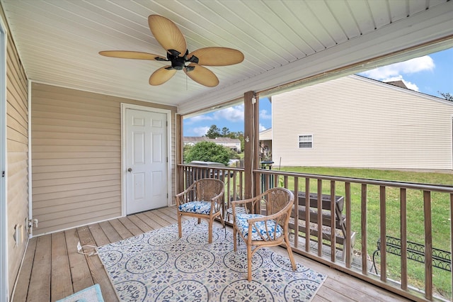 wooden deck featuring ceiling fan and a yard