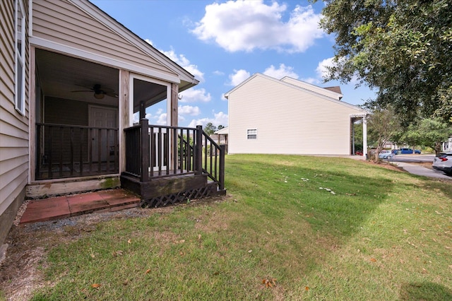 view of yard featuring a sunroom and ceiling fan