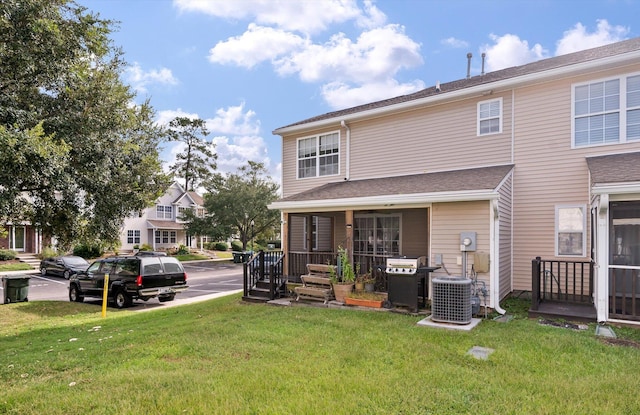 view of front of property with central air condition unit and a front yard