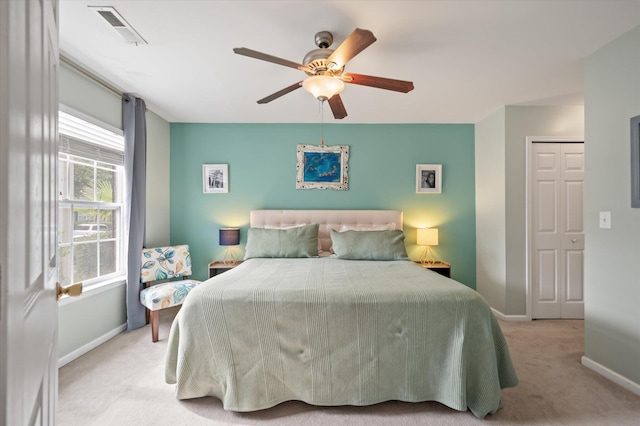 bedroom featuring ceiling fan, a closet, and light colored carpet