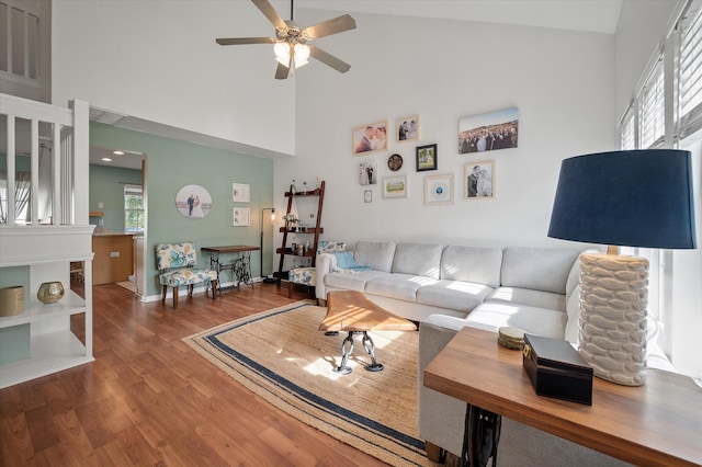 living room with hardwood / wood-style floors, ceiling fan, and high vaulted ceiling