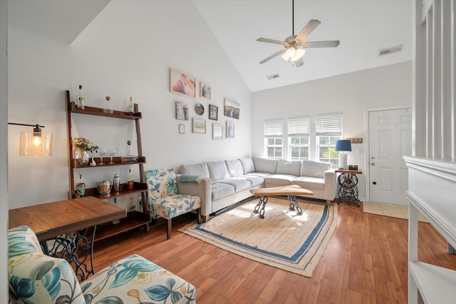 living room with hardwood / wood-style flooring, ceiling fan, and high vaulted ceiling