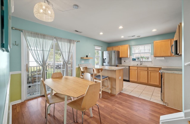 dining room with light wood-type flooring and a notable chandelier