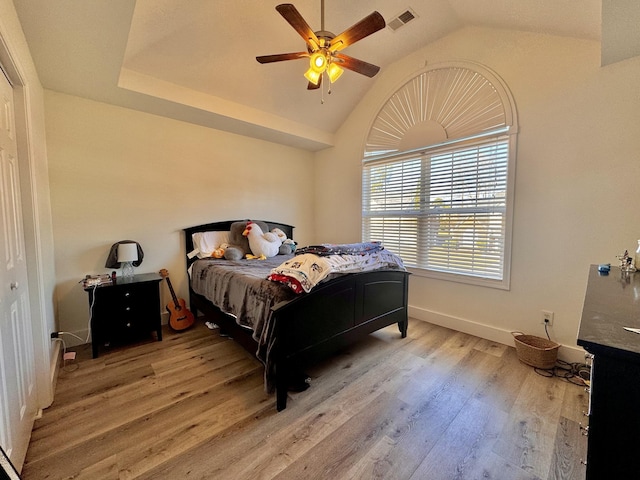 bedroom with light wood-type flooring, vaulted ceiling, and ceiling fan