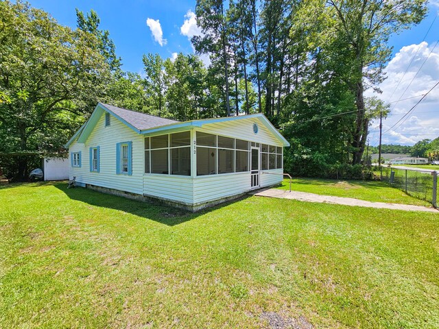 view of home's exterior with a yard and a sunroom