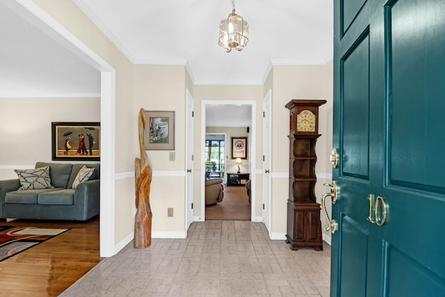 entrance foyer featuring an inviting chandelier, baseboards, light wood finished floors, and crown molding